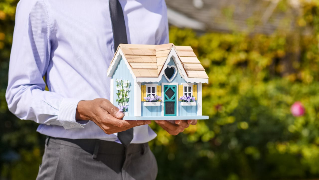 A man holding a model house.